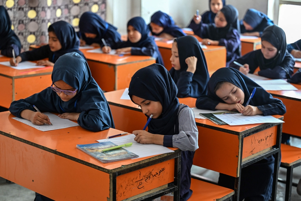 This photograph taken on July 21, 2026 shows Afghan girls taking their midterm exams at a primary school in Kabul. — AFP pic