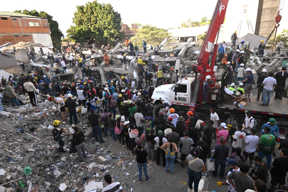 Rescuers and volunteers search for survivors amid the rubble of a collapsed building after an earthquake in Cali, Colombia on August 11, 2026.  — AFP pic
