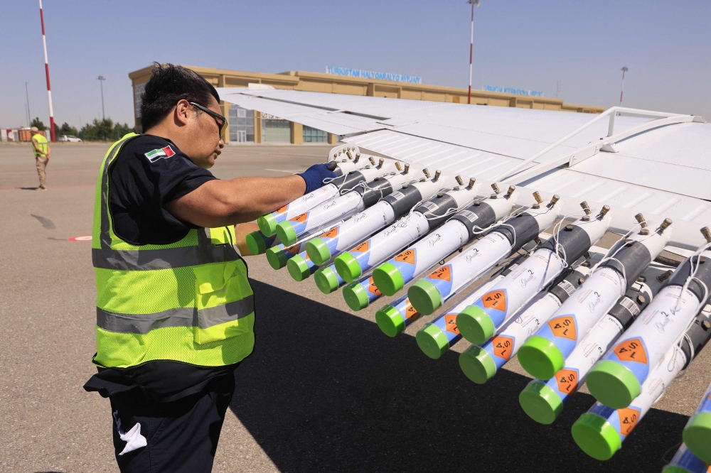 An engineer mounts hygroscopic (water-attracting) salt flares on a wing of a cloud-seeding plane of the UAE’s National Center of Meteorology in the airport of Turkistan in southern Kazakhstan on July 10, 2026. — AFP pic 