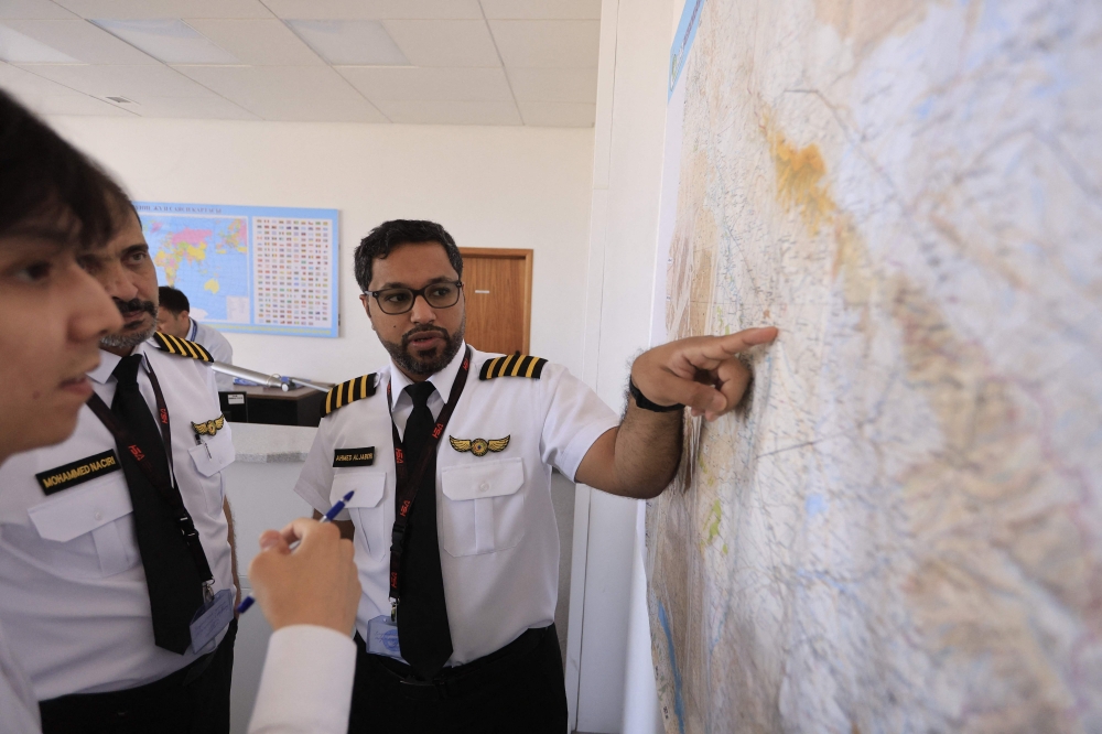 Ahmed Abdulla Aljaberi, 36, chief pilot, points at a map prior to a cloud-seeding mission of a specialized plane of the UAE’s National Center of Meteorology equipped with hygroscopic (water-attracting) salt flares at the airport of Turkistan in southern Kazakhstan on July 10, 2026. — AFP pic 