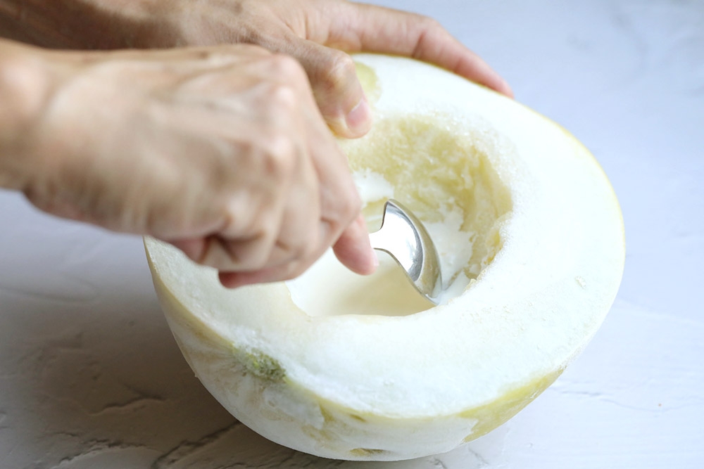 Scrape the frozen melon flesh into the cream. 