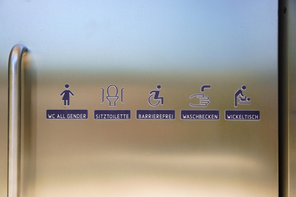 Signs and icons indicating the facilities are pictured on the door of a public toilet in the Augarten, a historic Baroque park in Vienna, Austria, on August 12, 2026. A Viennese woman is suing the city council for discrimination over access to public toilets, complaining that women must pay to use cubicles while men can use urinals for free. — AFP pic