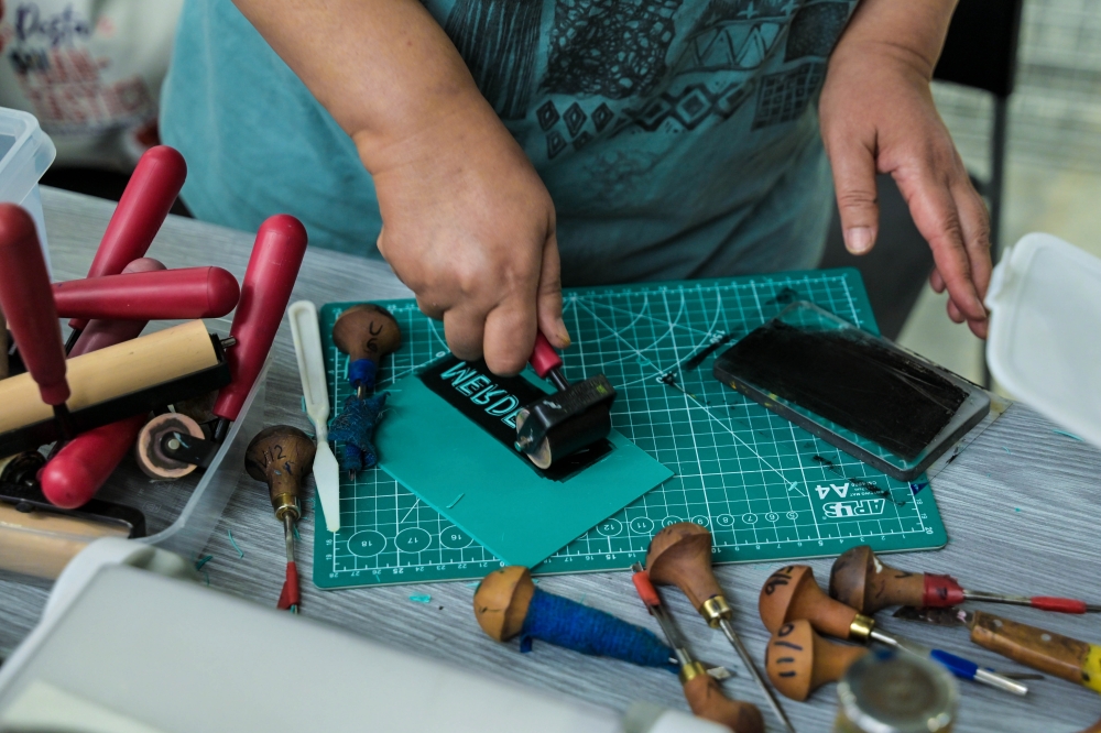 Multidisciplinary artist Norhayati Kaprawi, 60, or better known as Yati Kaprawi, demonstrating block printing techniques at the Puan-Tastic Festival in conjunction with the National Month at the GMBB Creative Community shopping complex recently. — Bernama pic