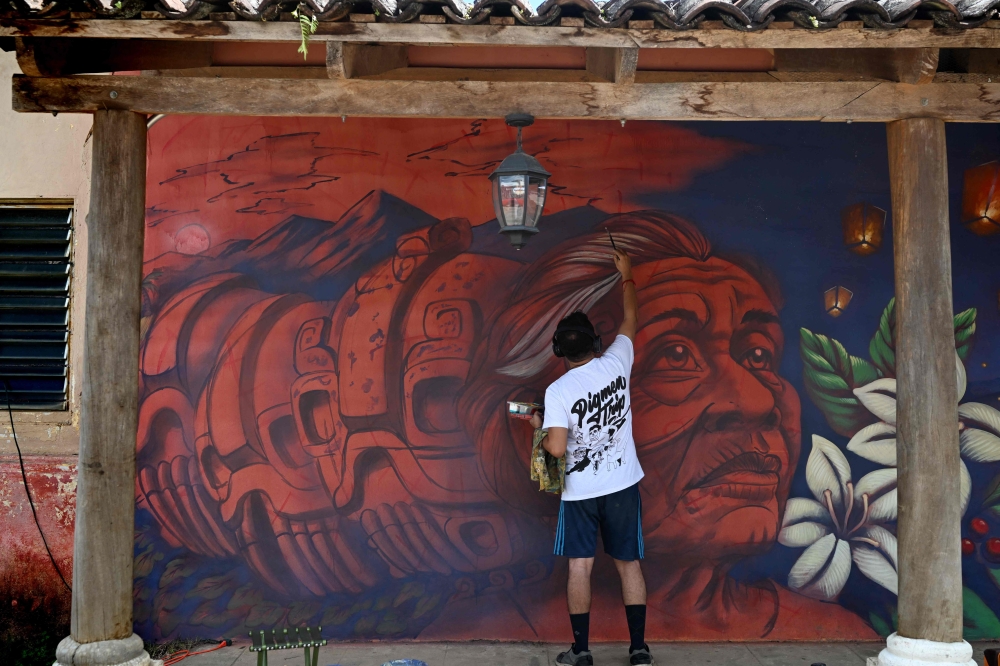 Salvadoran mural artist Gonzalo Vasquez works during the eighth edition of the PigmenTrip Muralism Festival -part of the local Festival del Jaguar- in Concepcion de Ataco, Ahuachapan, El Salvador, on August 15, 2026. — AFP pic