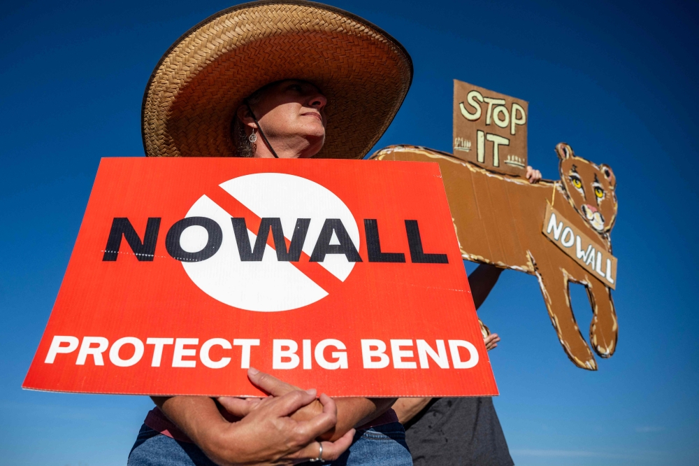 A woman holds a sign protesting plans by US President Donald Trump’s administration to build a section of border wall at Big Bend National Park in Study Butte, Texas, on August 15, 2026. The administration has since paused the US$1.7 billion project following fierce bipartisan opposition. — AFP pic