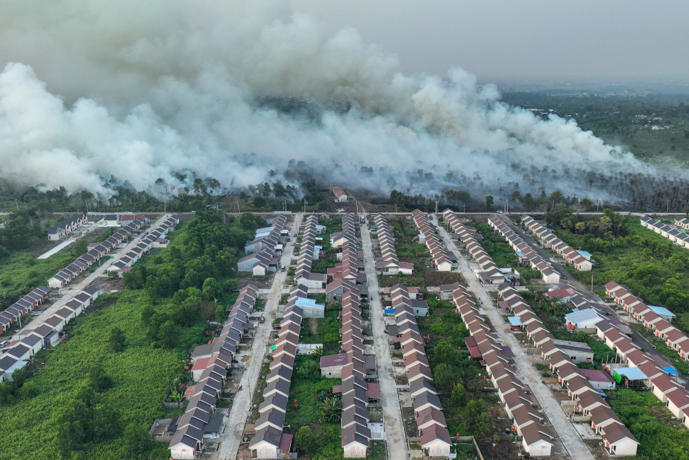 An aerial view shows smoke rising from a wildfire next to a housing complex in Kubu Raya, West Kalimantan on July 19, 2026. — AFP pic
