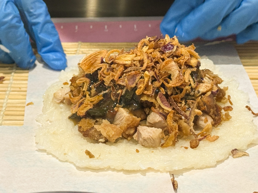 A wrap using sticky rice, cubed fried chicken, drizzled with the sauce of your choice (like Thai basil flavour), and covered with fried shallots is exceptionally good. — Picture by Lee Khang Yi