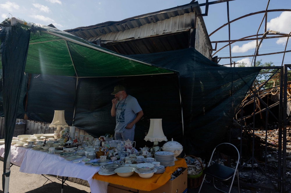 Vadym, a 72-year-old vendor, sells goods that survived the shelling at a damaged street market following strikes in Petrivka neighbourhood in Kyiv on August 9, 2026, amid the Russian invasion of Ukraine. — AFP pic 