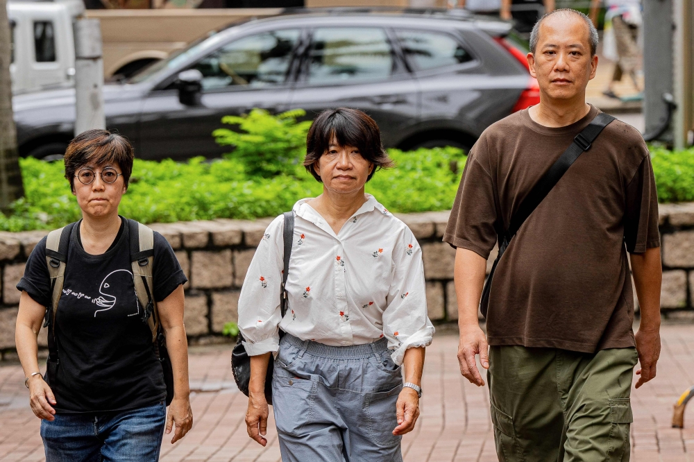(From left) Lau Ka-yee, former Hong Kong Alliance standing committee member, Elizabeth Tang Yin-ngor, wife of former union leader Lee Cheuk-yan, and Kwan Chun-pong, former member of Hong Kong Alliance, arrive at the West Kowloon Magistrates’ Courts ahead of the verdict in the national security trial of two pro-democracy Tiananmen activists, in Hong Kong August 21, 2026. — AFP pic