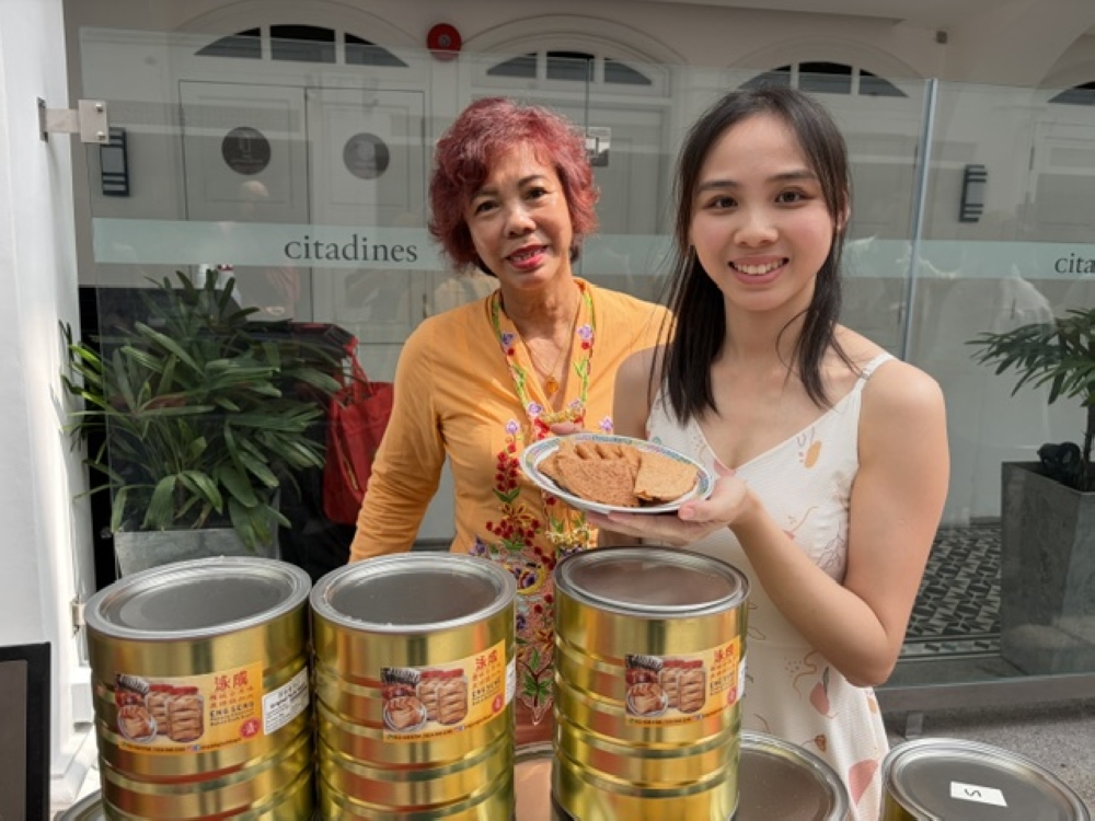 Saik Wai Fong and her daughter Quah Ai Yin with the ‘kuih kapit’ they made. — Picture by Opalyn Mok
