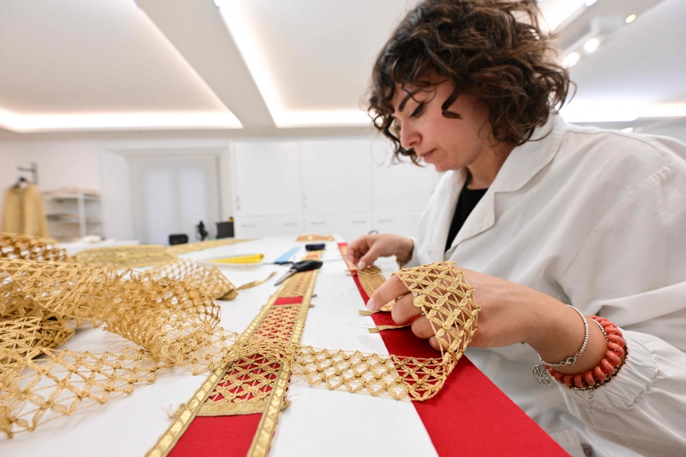 An employee hand-embroiders a liturgical vestment at the LAVS (Laboratorio Arte Vesti Sacre) Italian atelier specialized in sacred vestments, founded in 2001 by artist and designer Filippo Sorcinelli, in Santarcangelo di Romagna, central Italy, on August 21, 2026.  — AFP pic