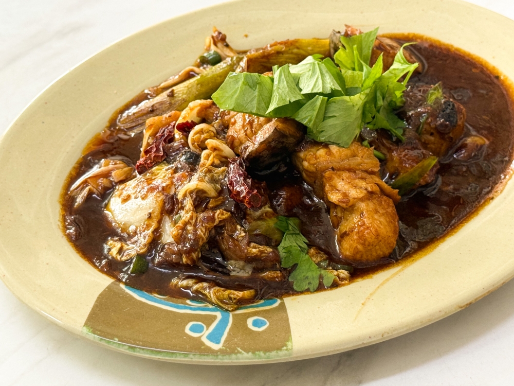 Teochew-style Hometown Stir-fried Fish has a dark, thick sauce flavoured with aromatics like leeks, dried chilies, lard fritters, and sliced bird's eye chilies.