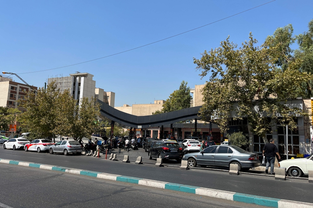 Cars queue at petrol stations in Iran after authorities announced plans to reduce petrol quotas while keeping subsidised prices unchanged. — AFP pic