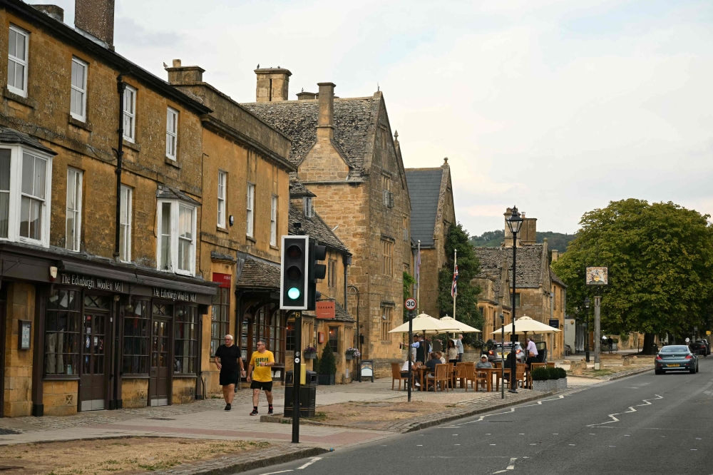 People walk in the village of Broadway, in a region known as the Cotswolds, west of London on August 26, 2026.