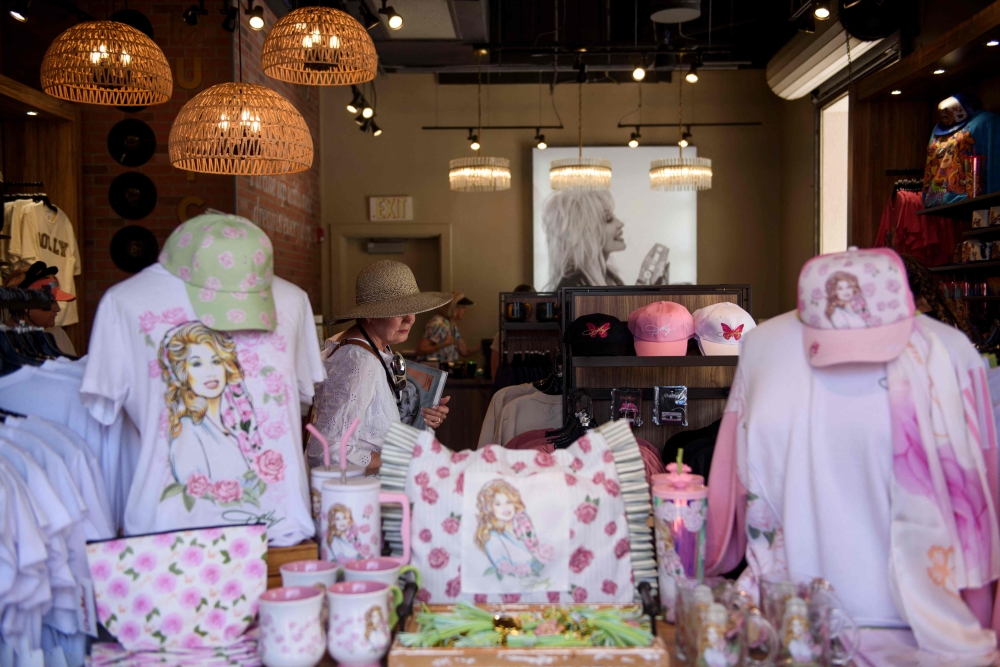 A guest peruses Dolly Parton themed items for sale while visiting Dollywood theme park on August 26, 2026 in Pigeon Forge, Tennessee. Fans of Dolly Parton have gathered at Dollywood, the beloved theme park she helped create, after she died at the age of 80. — Melissa Sue Gerrits/Getty Images North America/Getty Images pic via AFP