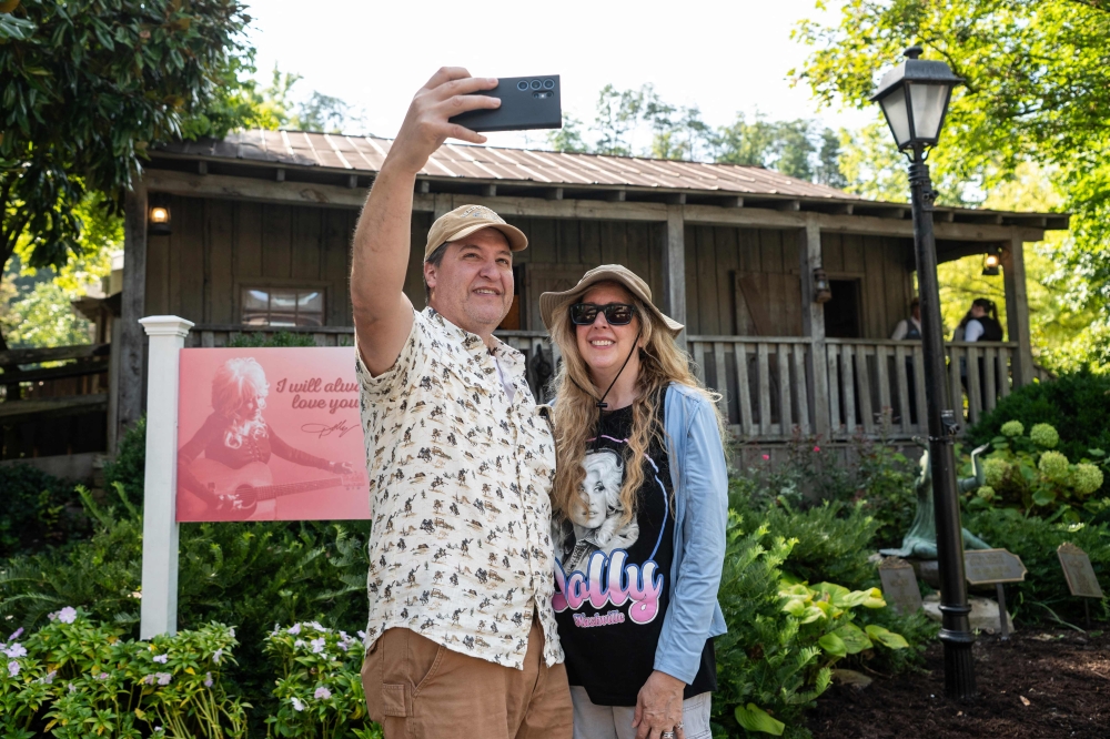 James and Laura Feragola take a selfie in front of a replica of Dolly Parton’s childhood home at the Dollywood theme park in Pigeon Forge, Tennessee August 26, 2026. Parton was more than a singer — she wrote 3,000 songs, acted in major Hollywood films and donated millions of dollars to charities in her home state and beyond. — AFP pic