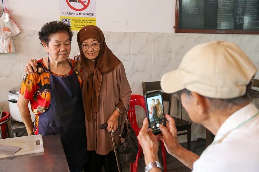 Many devoted customers like Rohani Abdullah and her husband Rosley Hussin have visited to eat their favourite bowl of curry ‘mee’ and snap a photograph with Madam Ho as a keepsake. — Picture by Choo Choy May