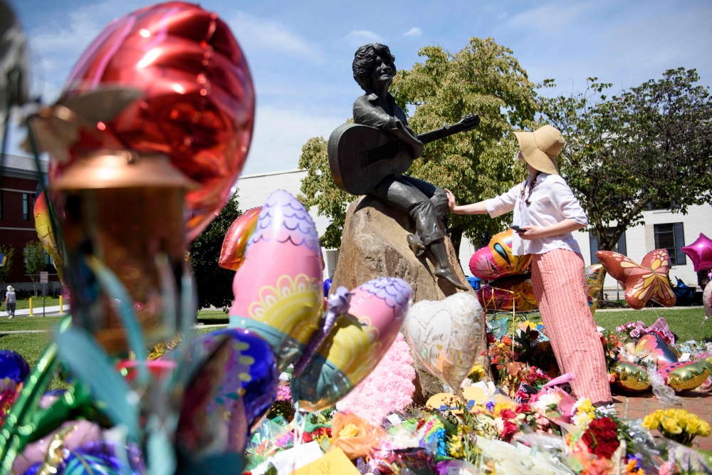 A woman pauses beside a statue of Dolly Parton at the Sevier County Courthouse in Sevierville, Tennessee, on August 26, 2026. — Getty Images pic via AFP