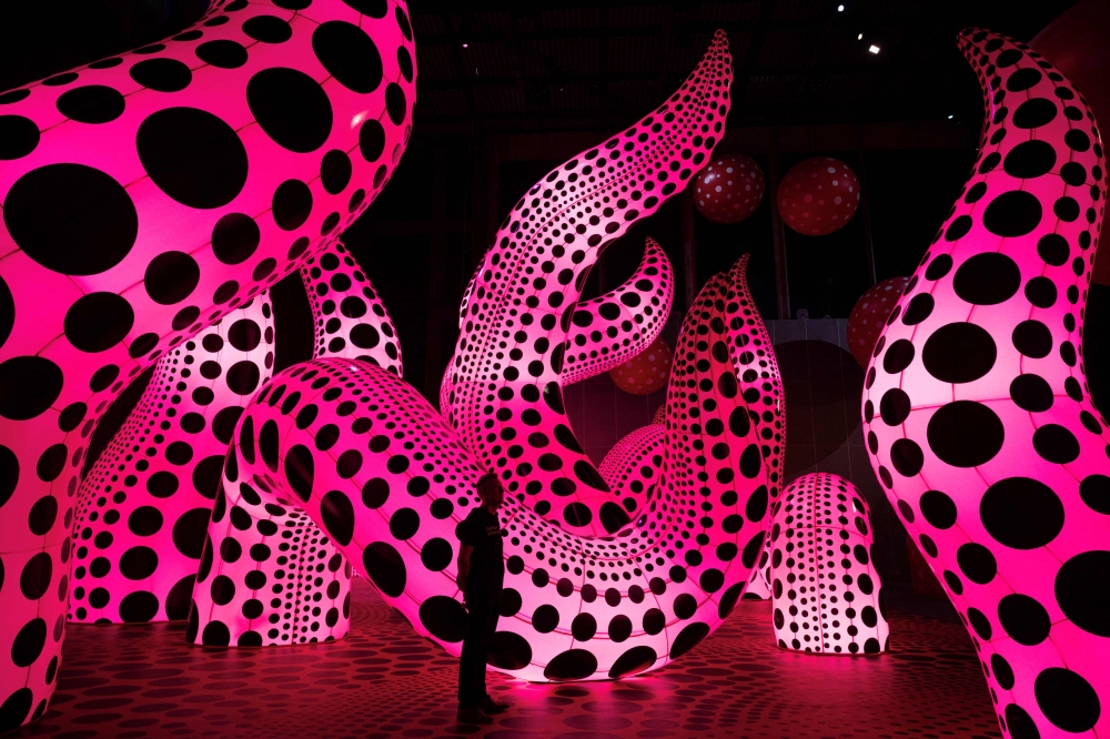 A man admires an artwork entitled ‘A Bouquet of Love I Saw in the Universe’ which features in an exhibition by Japanese artist Yayoi Kusama entitled ‘You, Me and the Balloons’ in the Aviva Studios gallery in Manchester June 29, 2023. — AFP pic