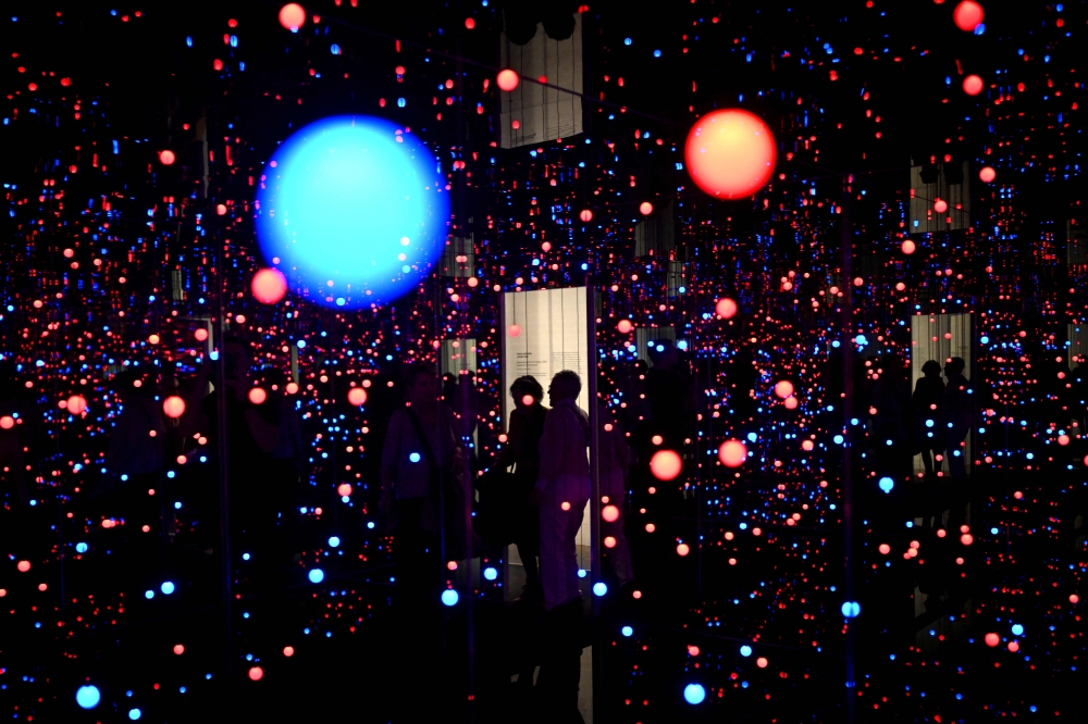 Visitors stand inside the art installation ‘Gleaming Lights of the Souls’ created by Japanese artist Yayoi Kusama at Louisiana Museum of Modern Art in Humlebaek, Denmark on March 20, 2025. — AFP pic