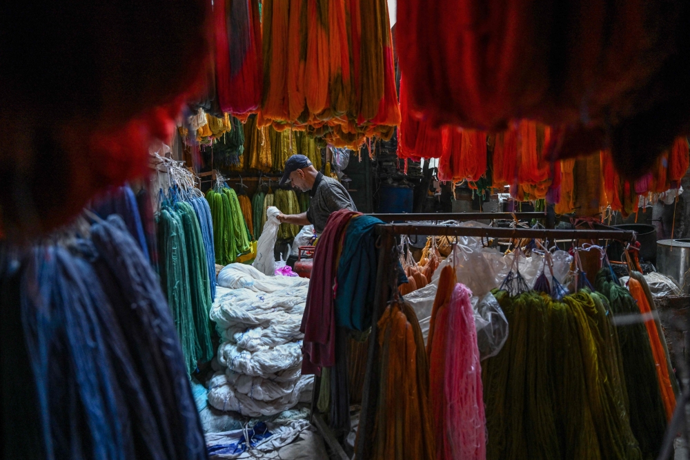 A worker sorts silk yarn at a traditional dyeing workshop in Srinagar, India on November 1, 2025, as Kashmir’s handwoven carpet industry struggles to attract younger workers. — AFP pic