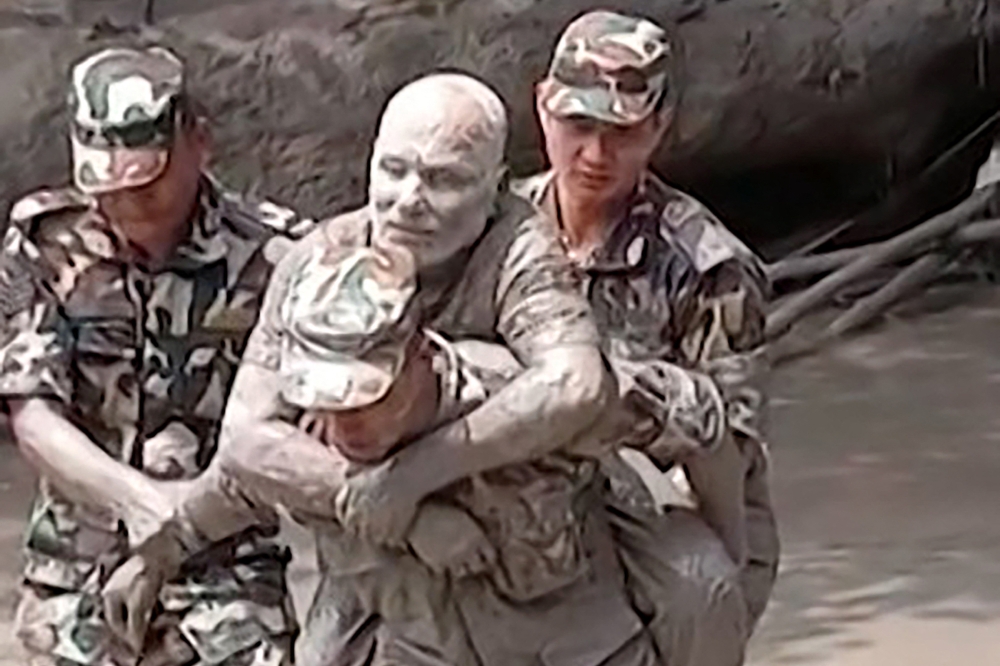 This handout video grab from a UGC footage of Nepal Army taken and released on August 26, 2026 shows a military personnel rescuing a man stranded by massive floods and landslides along the Nepal-Tibet border. — AFP pic  