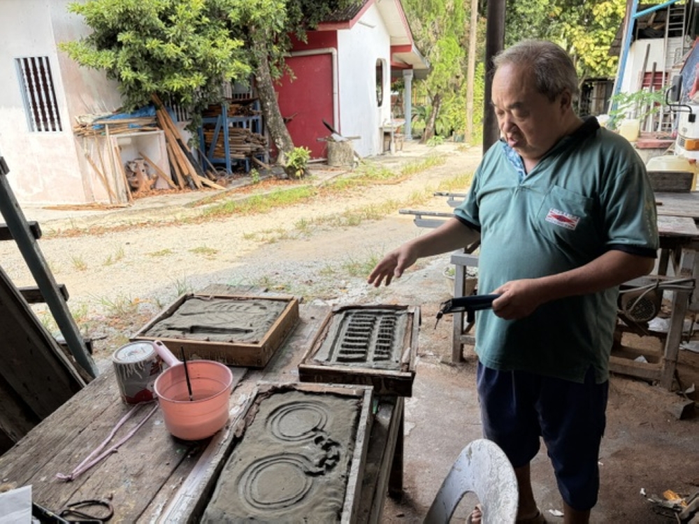 Ong Chin Chye showing the moulds used for some decorative parts to speed up process. — Picture by Opalyn Mok