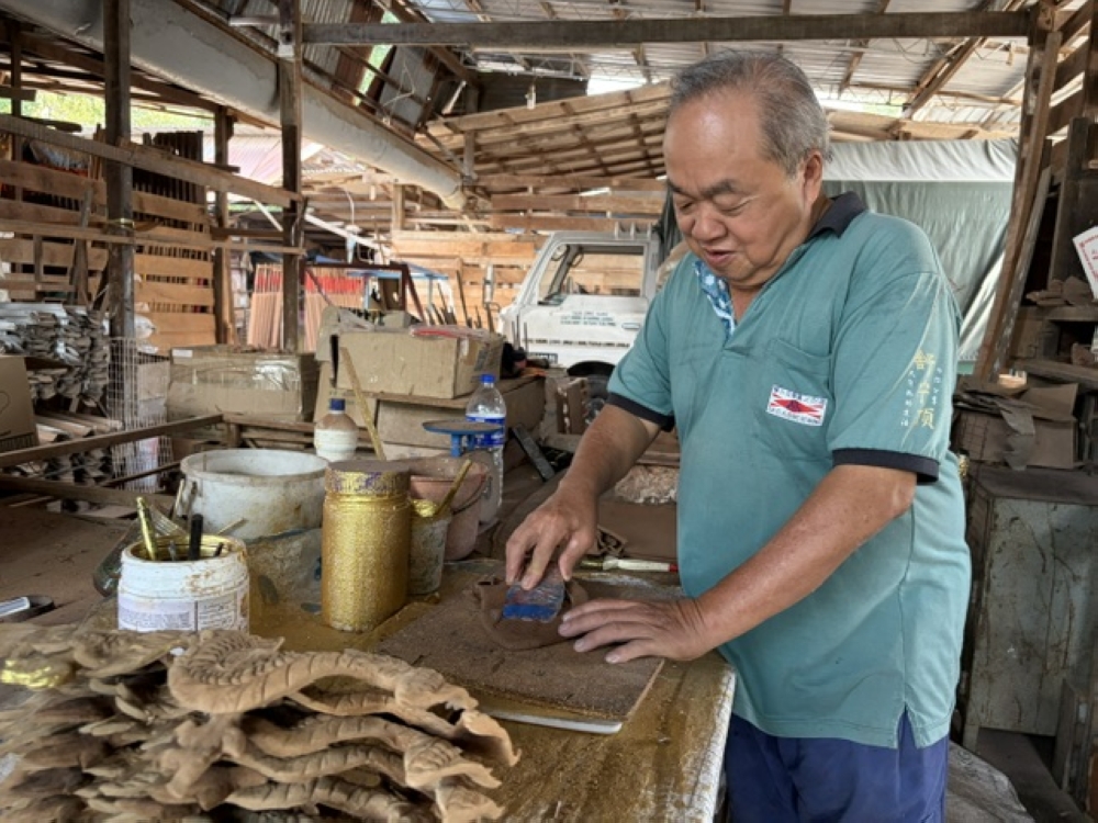 Ong Chin Chye showing how he used a tool to carve scales. — Picture by Opalyn Mok