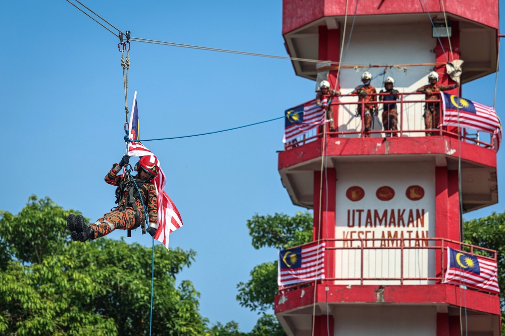 Fire and Rescue Department personnel perform a presentation of the Jalur Gemilang to Kuala Lumpur and Putrajaya Information Department director Normaizatulakmal Tujad in conjunction with the Wilayah Persekutuan Kuala Lumpur and Putrajaya-level Kembara Merdeka Jalur Gemilang (KMJG) 2026 x JAGO convoy at the Seputeh Fire and Rescue Station in Kuala Lumpur on August 23, 2026. — Bernama pic