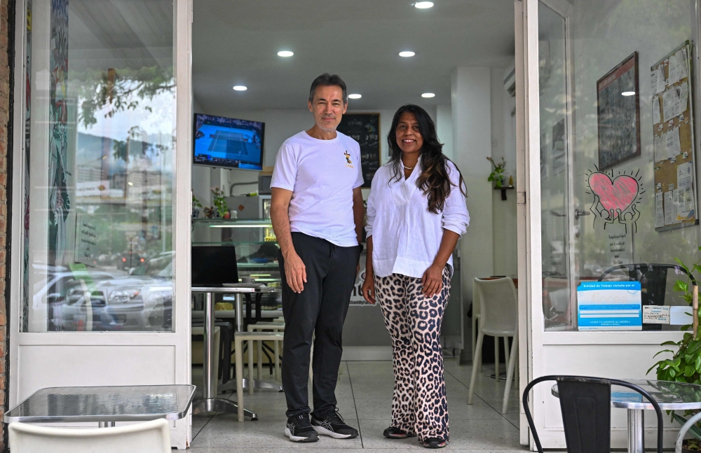 Venezuelan seamstress Javier Chacon (left) and pastry chef Marbelis Daliz (right) pose for a photo at their pastry shop in Caracas on August 21, 2026. — AFP pic