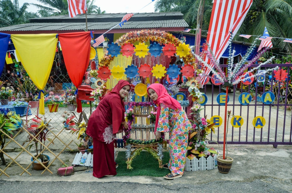 Two people exhibit decorations at their home in conjunction with National Month in Kampung Baru Tok Dor, Jertih on August 28, 2026. — Bernama pic