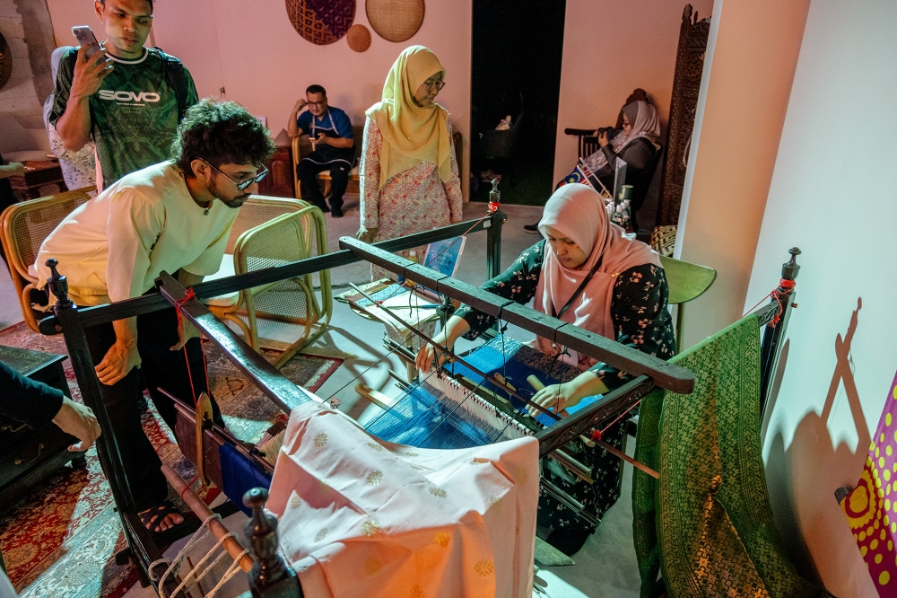 Visitors watch an artisan demonstrate traditional handloom weaving at Ombak KLCC in Kuala Lumpur, Aug 28, 2026. — Picture by Firdaus Latif.