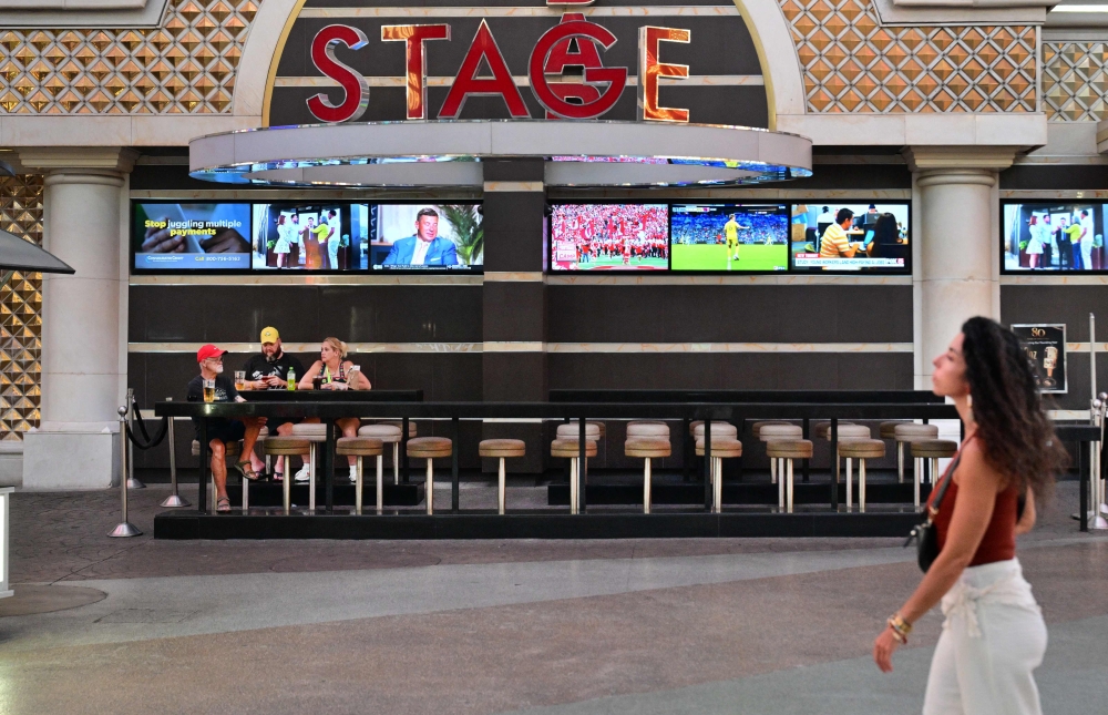 Three people sit among rows of empty chairs at a Fremont Street establishment in Las Vegas, Nevada, on August 19, 2026, as visitor numbers in the gambling hub fell 7.5 per cent in 2025 – the sharpest decline outside the Covid pandemic. — AFP pic
