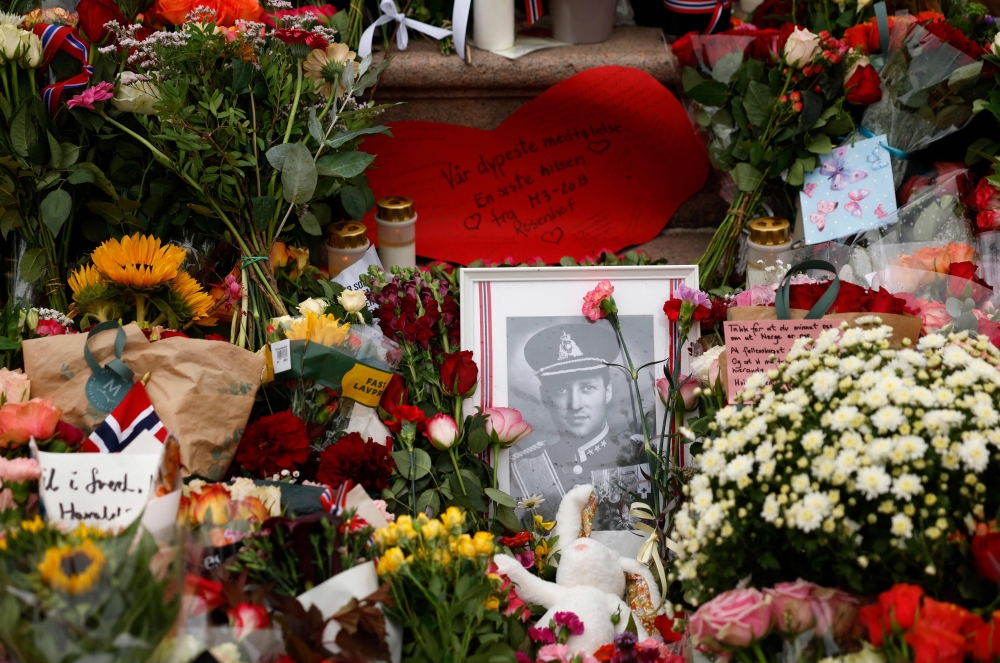 A photograph of late King Harald V of Norway is seen among flowers at a makeshift memorial at the Royal Palace square in Oslo on August 28, 2026, as thousands gathered to pay their respects to the monarch, who died aged 89 after 35 years on the throne. — AFP pic