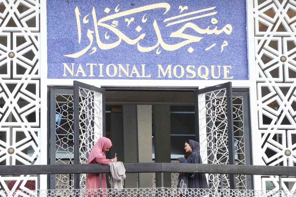 Visitors take pictures in front of Masjid Negara on the first day of Hari Raya Aidilfitri April 10, 2024. Tunku Abdul Rahman rejected a proposal for it to bear his name and instead chose Masjid Negara — the National Mosque. — Picture by Choo Choy May.