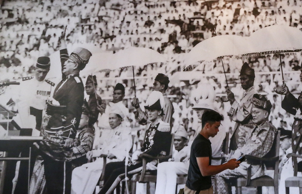 A man walks past giant poster of Tunku Abdul Rahman during the declaration of Independence at the ‘Jalan Merdeka Exhibition’, an exhibition celebrating the history of our Independence Day at Carcosa and Seri Negara August 13, 2018. — Picture by Azneal Ishak 