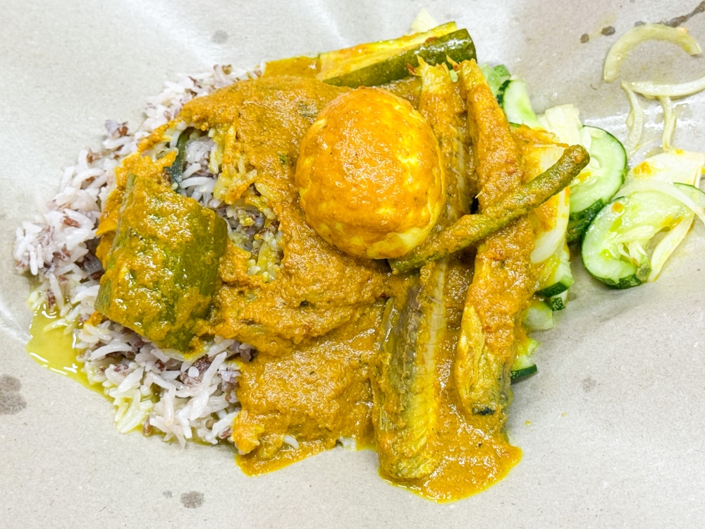 Nasi Dagang Ikan combines the slightly chewy brown flecked rice with that thick, creamy ‘gulai’ cooked from a legacy recipe and served with chunks of tuna fish. — Picture by Lee Khang Yi
