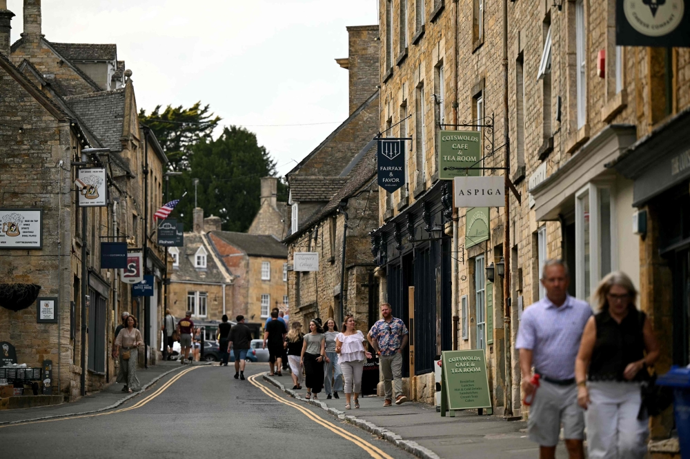 People walk along the main shopping street in Stowe on the Wold, in Gloucestershire, a region known as the Cotswolds, central England August 26, 2026. — AFP pic