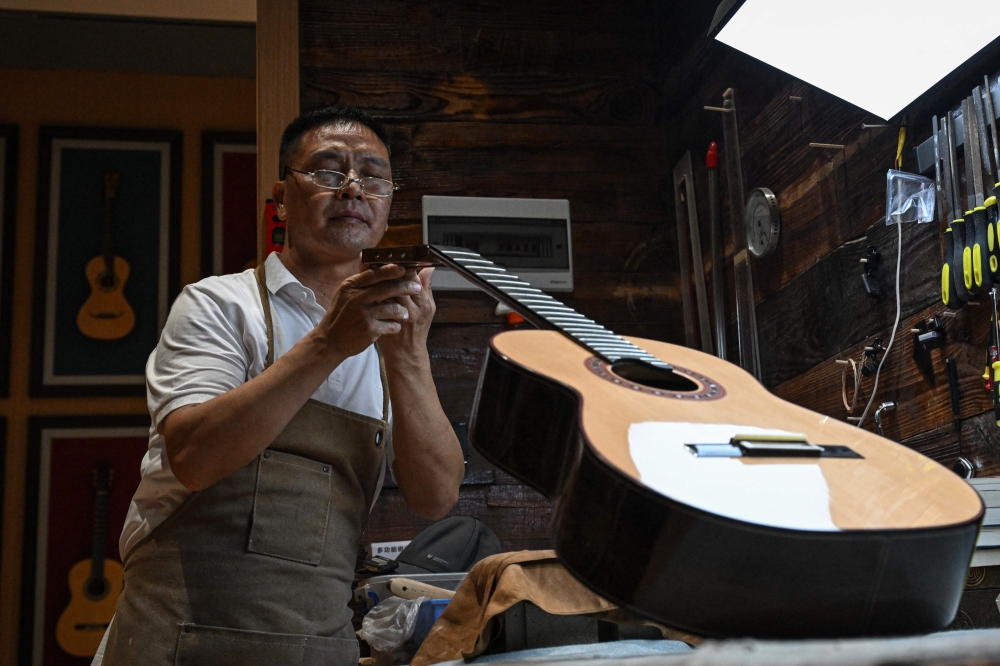 This photo taken on July 27, 2026 shows master luthier Zhang Weiyi making a guitar at his workshop in Zheng’an, in south-western China’s Guizhou Province. — AFP pic