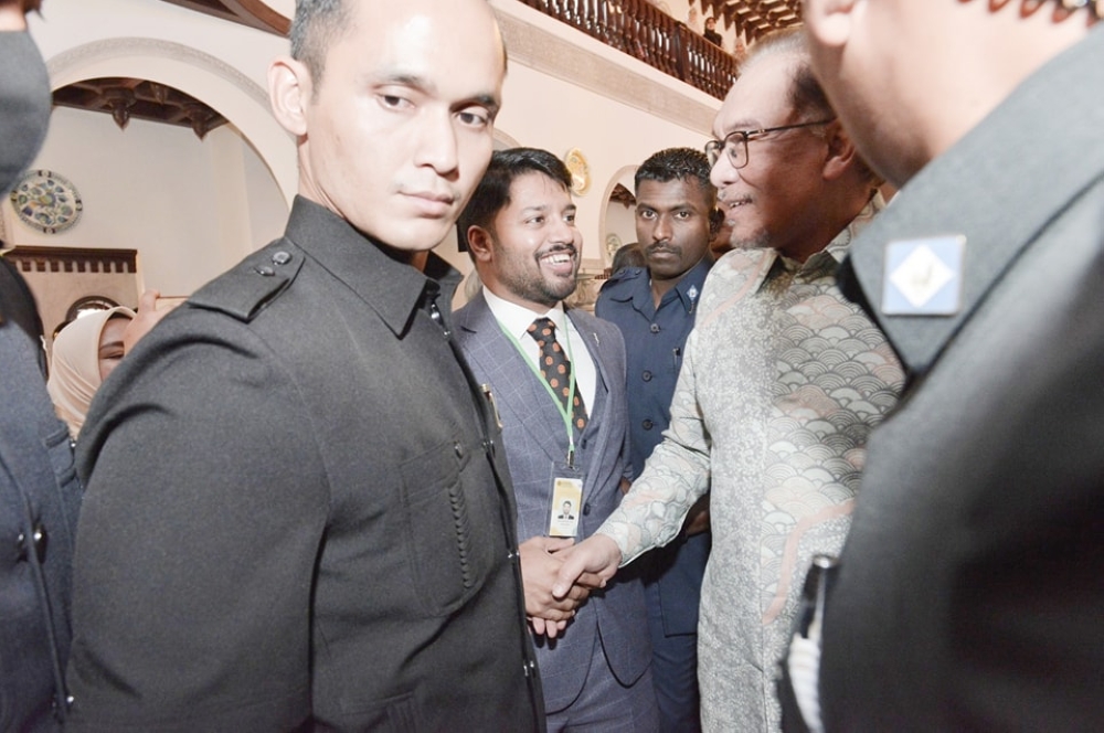 The author, Nahrizul Adib Kadri (centre) greets Prime Minister Datuk Seri Anwar Ibrahim. — Picture courtesy of the author