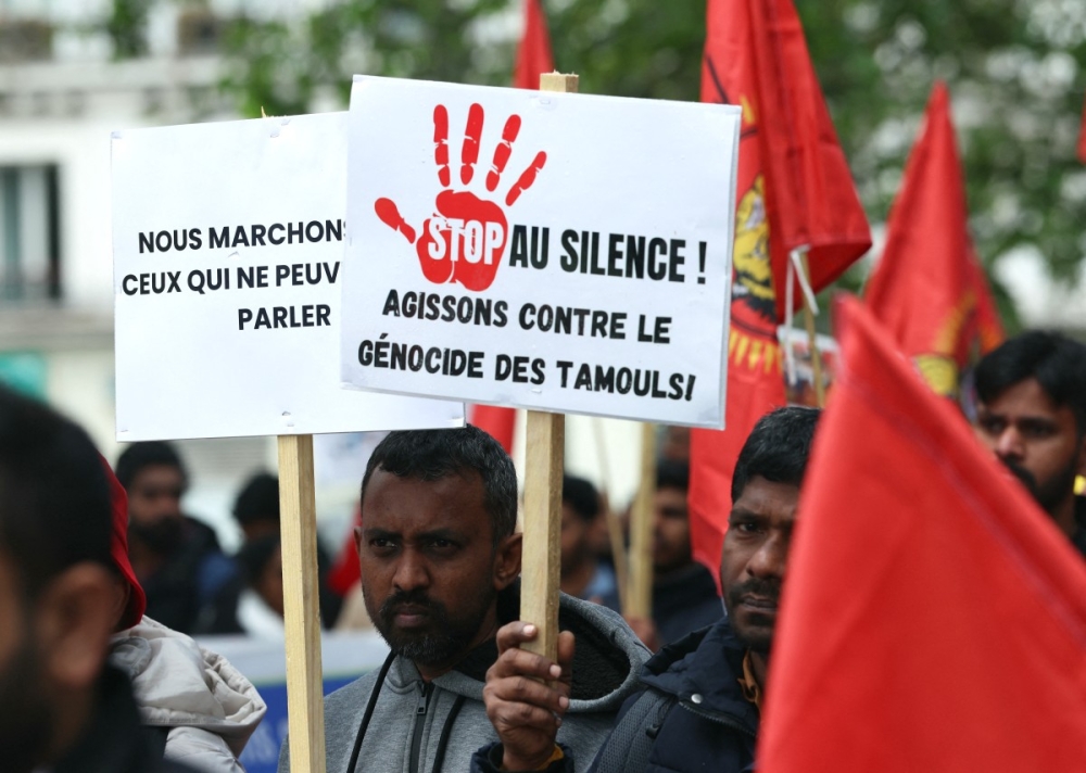 A member (centre) of the Tamil community in France holds a placard reading “Stop the silence. Let’s take action against the genocide of the Tamils” during a protest march in Paris on May 18, 2026, demanding that Sri Lanka recognize what they describe as the Tamil genocide. — AFP pic