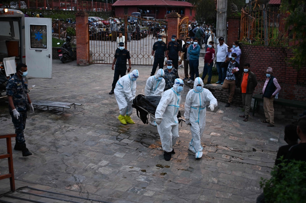 Security personnel move the bodies of unidentified flood victims from an ambulance to a mortuary at Pashupatinath temple in Kathmandu on September 2, 2026. — AFP pic 