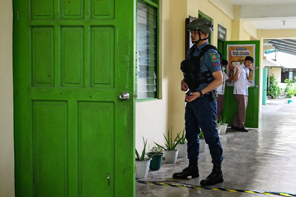 A policeman instructs students to evacuate during a nationwide school drills to safeguard students from armed intruders, at a school in San Rafael, Bulacan September 3, 2026. — AFP pic 