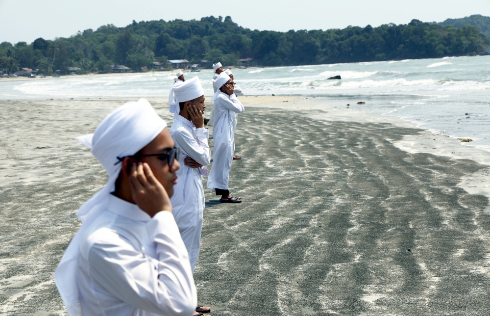 Students of Madrasatul Quran Ar-Redha Tahfiz in Taman Desaru Utama recite the call to prayer and perform special prayers to aid search and rescue (SAR) operations for three missing victims off Tanjung Lompat Beach in Kota Tinggi on August 3, 2026. — Bernama pic