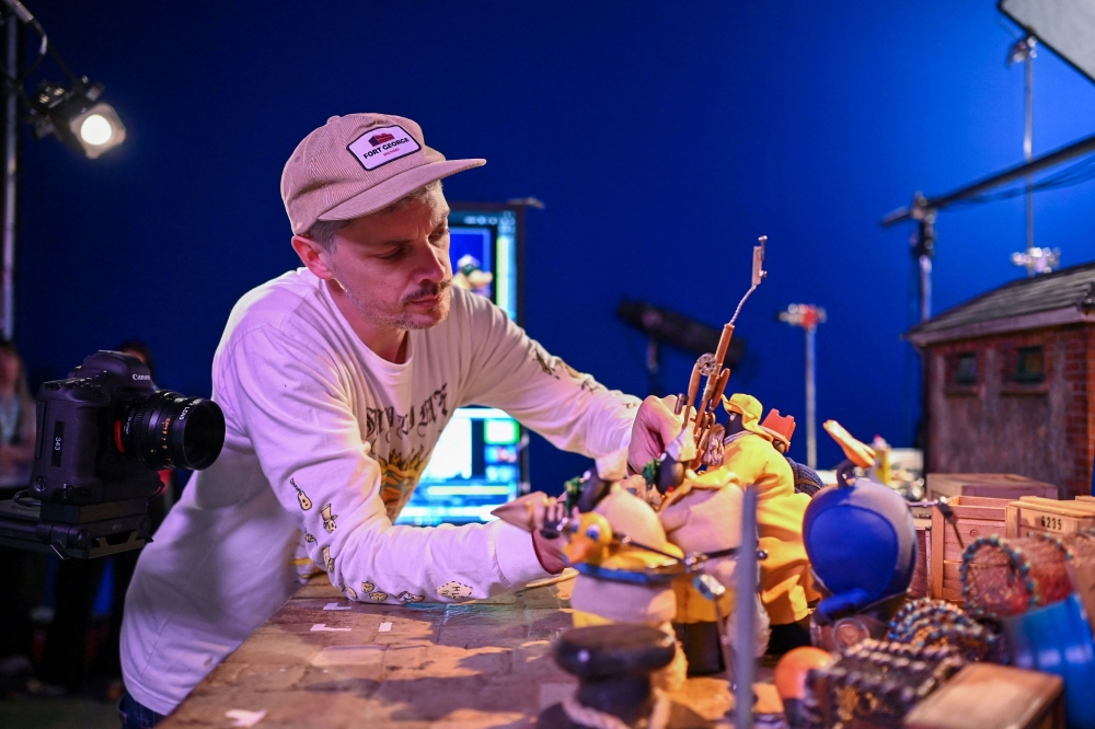 Ed Jackson, an animator for ‘Shaun the Sheep: The Beast of Mossy Bottom’, working on a set at Aardman Animations studios in Bristol. — AFP pic