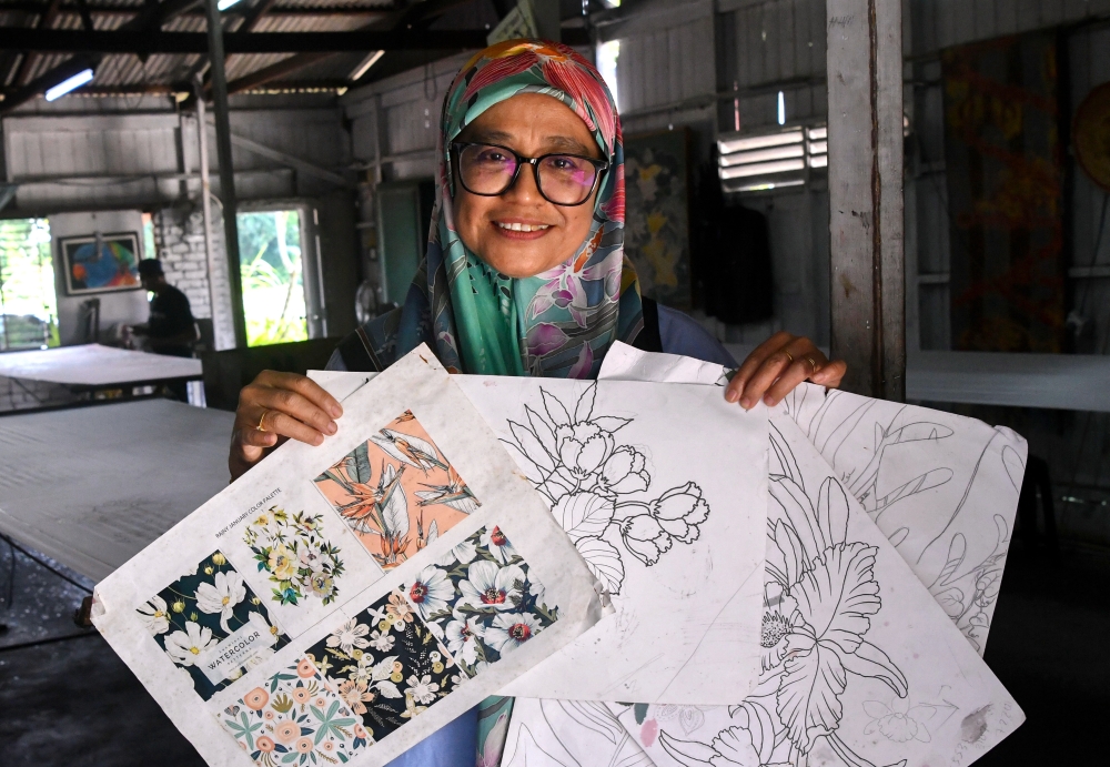 Rosliza shows a few early sketches that will evolve into vibrant, creative batik designs. — Bernama pic