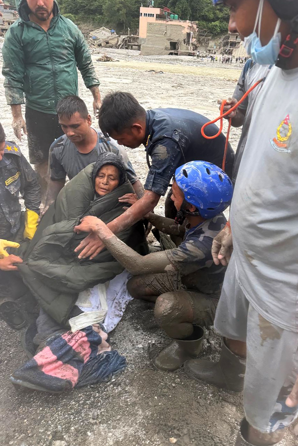 This handout photograph taken and released on September 5, 2026 by Nepal Army shows security personnel assisting a woman rescued from a flash-flood ravaged house at Betrawati in Nepal's Nuwakot district. Devastating floods on the China-Nepal border have killed at least 1,287 people in Nepal, the disaster authority said September 4, with the number of missing at 5,083. — Nepal Army handout via AFP pic