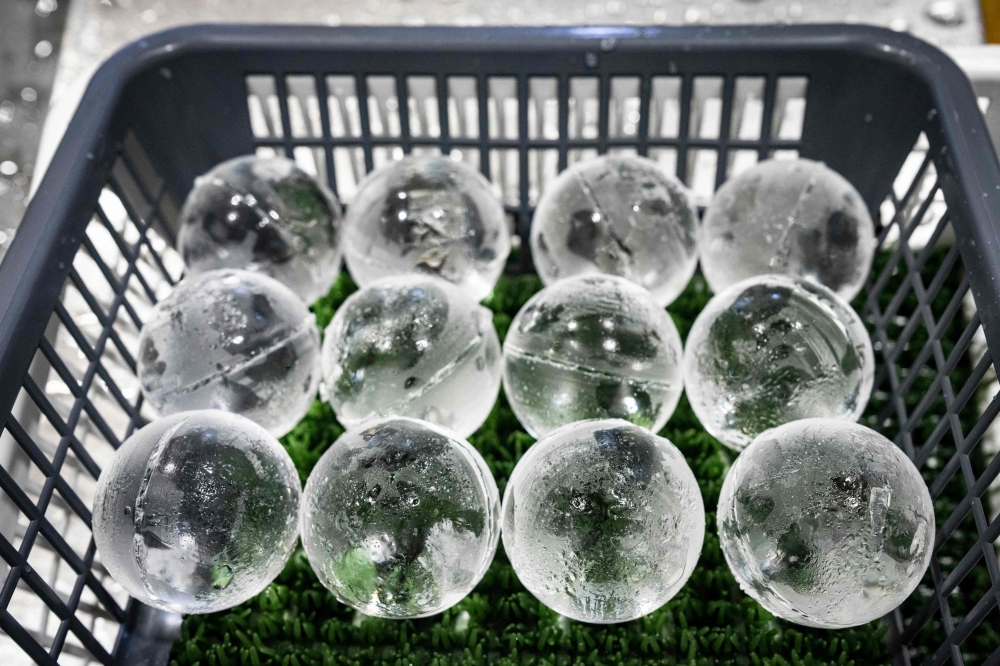 Ice spheres sit in a basket after being cut at the Kuramoto Ice factory. — AFP pic