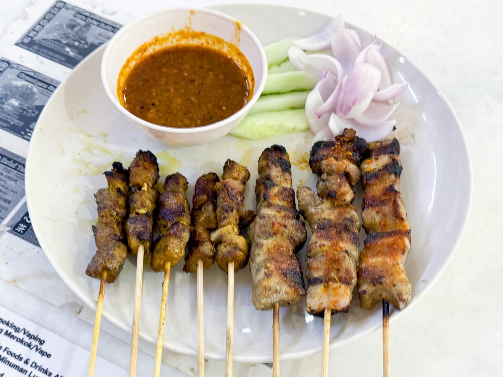 Satay Babi is served with a peanut sauce laced with sweet pineapple and BBQ Pork Skewers are sprinkled with chilli powder. — Picture by Lee Khang Yi