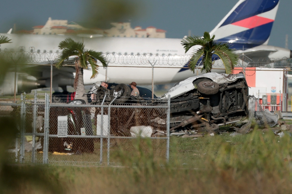 Investigators walk near damaged vehicles at Miami International Airport in Miami, Florida September 6, 2026. — Joe Raedle/Getty Images North America/Getty Images pic via AFP